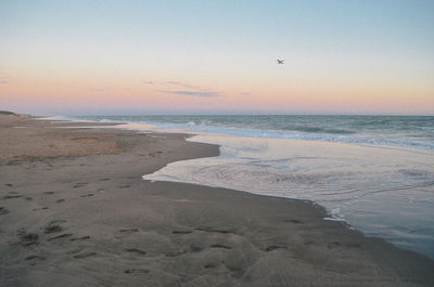 Scenic view of beach against sky during sunset