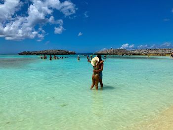 Rear view of man standing in sea against sky