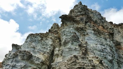 Low angle view of cliff against sky