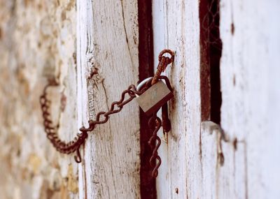 Close-up of rusty chain on wooden door