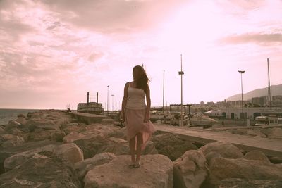 Rear view of woman standing on rock