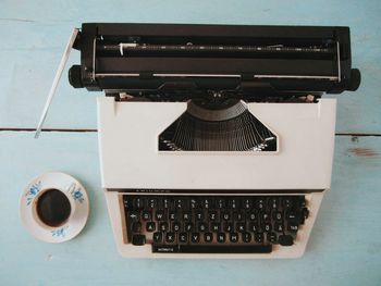 High angle view of black coffee by typewriter on table