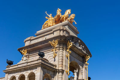 Low angle view of statue against blue sky