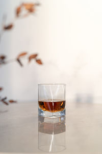 Single glass with bourbon on a marble table