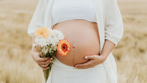 Midsection of woman holding bouquet