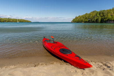 Kayak on beach against sky