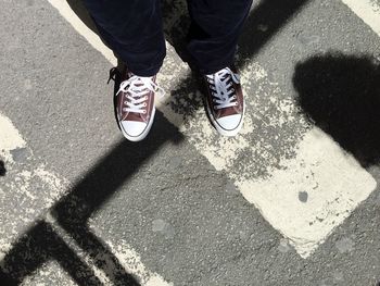 Low section of man standing on road