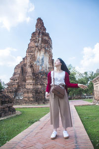 Full length of happy young woman standing in temple