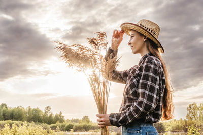 Woman wearing hat standing against sky