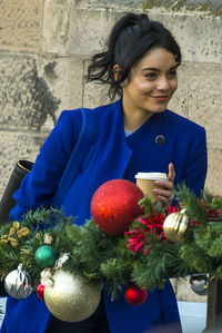 Portrait of woman holding fresh red flowers