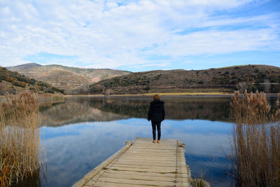 Rear view of man standing on pier