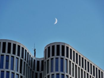 Low angle view of modern building against blue sky