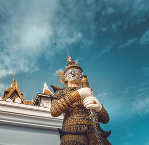 Low angle view of statue against building against sky