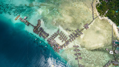 Tropical island mabul in the blue sea with a coral reef and the beach. semporna, sabah, malaysia.