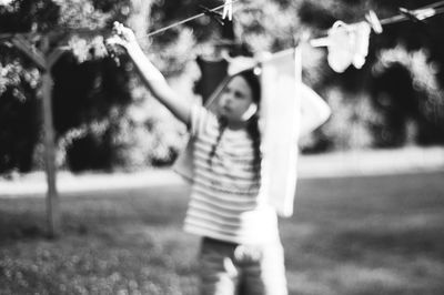 Girl drying clothes on clothesline at back yard