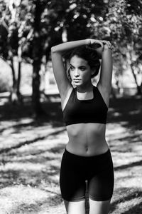 Teenage girl with arms raised exercising in park