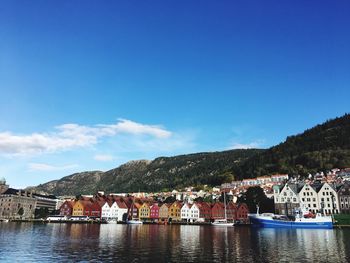 Scenic view of river and town against blue sky