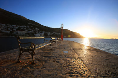 Scenic view of beach against clear sky during sunset