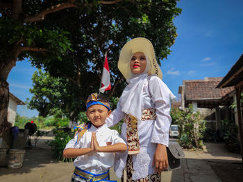 Portrait of smiling couple standing against trees