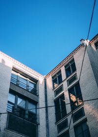 Low angle view of buildings against clear blue sky