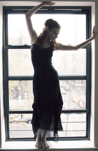 Full length of young woman standing by railing