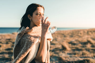 Portrait of mature man drinking water from beach