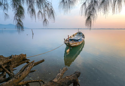 Boat moored on sea against sky