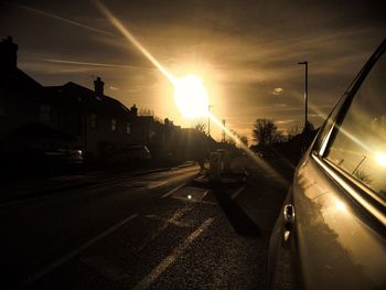 Cars on road against sky during sunset