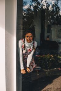 Portrait of woman standing by window