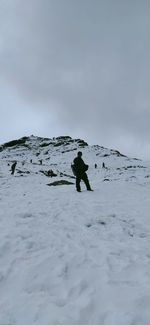 Rear view of woman walking on snow covered landscape