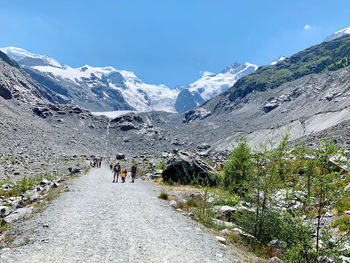 People walking on mountain against sky