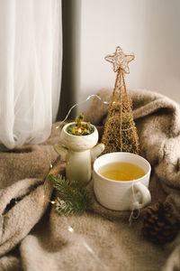 Hot tea, candles, christmas golden balls and decorations. christmas holiday mood