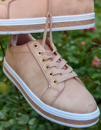 Close-up of beige shoes hanging outdoors