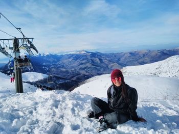 Woman on snow covered mountain against sky