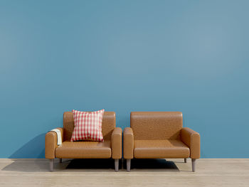 Empty chairs and table against blue wall at home