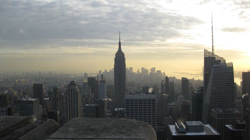 Modern buildings in city against cloudy sky