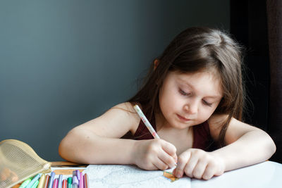 Girl writing on book at home