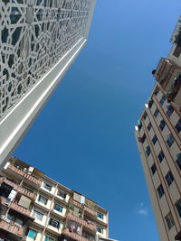 Low angle view of buildings against clear blue sky