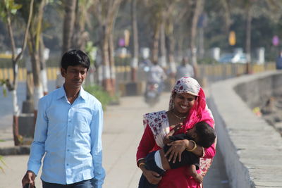 Parents with child walking on footpath in city