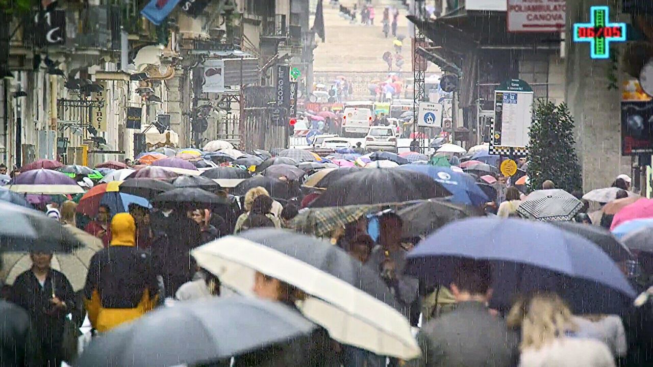 PEOPLE WALKING ON STREET IN RAIN