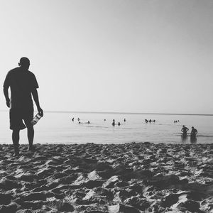 People at beach against sky