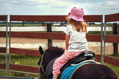 Rear view of woman riding horse