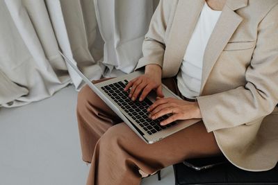 Midsection of woman using laptop