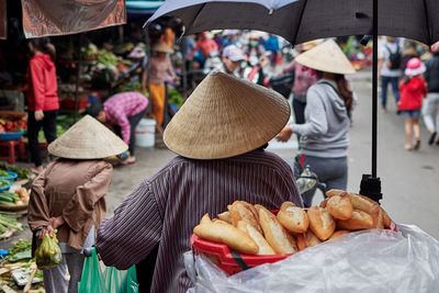 Rear view of people at market stall in city