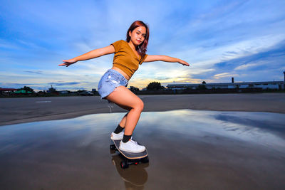 Asian women playing surf skate or skates board outdoors.