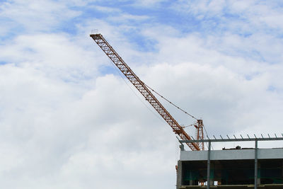 Low angle view of crane against sky