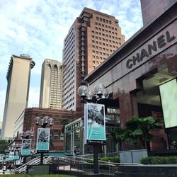 Low angle view of road sign against sky in city