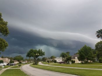 Houses by trees against sky