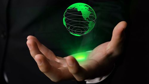 Close-up of person hand holding ball against black background