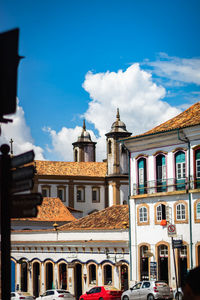 Buildings in city against cloudy sky